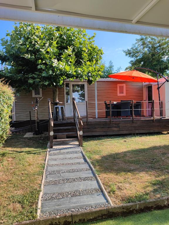un escalier menant à une maison avec une table et un parasol dans l'établissement Le ptit plaisir, à Auch