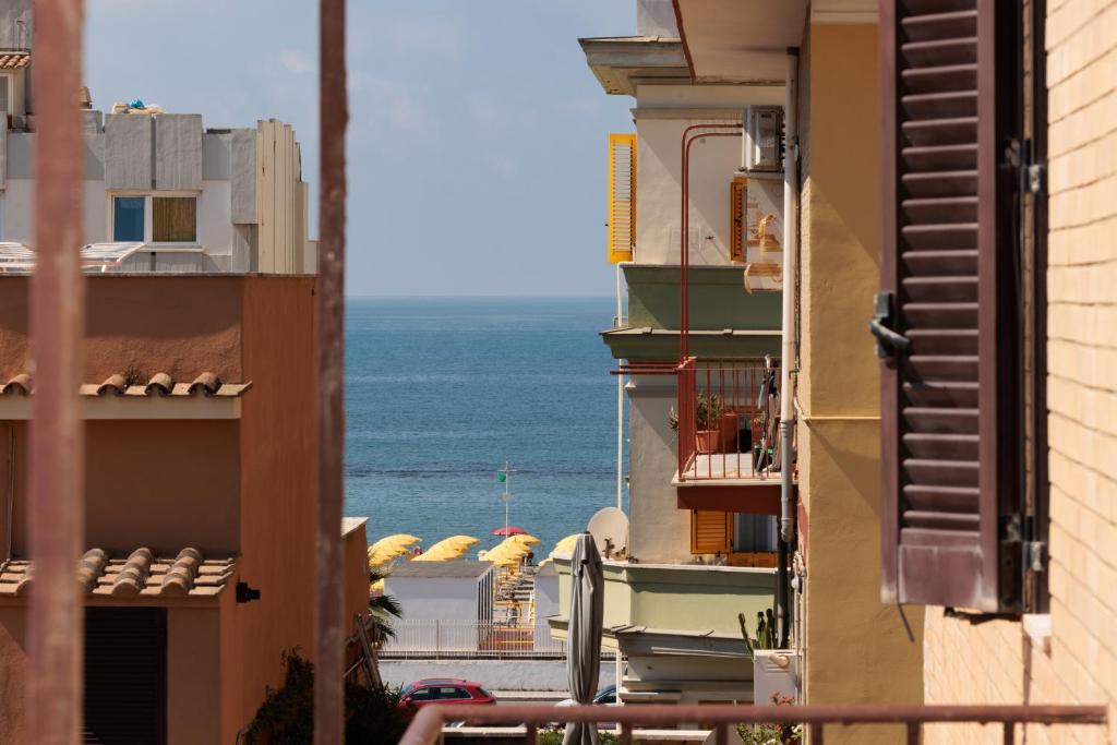 a view of the ocean from between two buildings at L'Angolo di Mare in Lido di Ostia