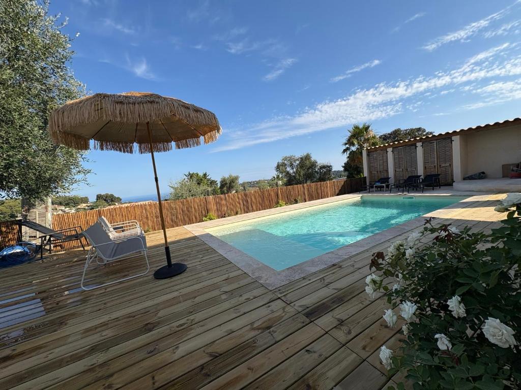 une terrasse avec un parasol, une chaise et une piscine dans l'établissement Villa Nomade proche de Cannes, à Vallauris