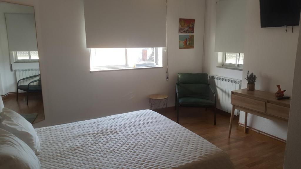 a bedroom with a bed and a desk and a chair at Moradia Vinhais in Vinhais