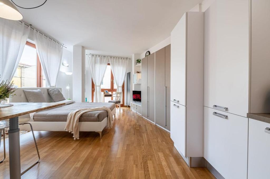 a white bedroom with a bed and a table at SuiteCentroStorico-Leaning Tower-Self check-in-AC in Pisa