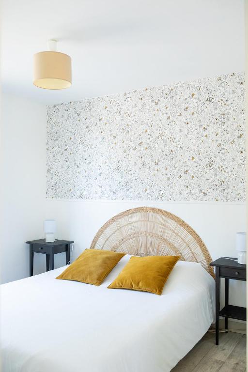 a bedroom with a white bed and two tables at La Casinière Coëtquidan in Guer