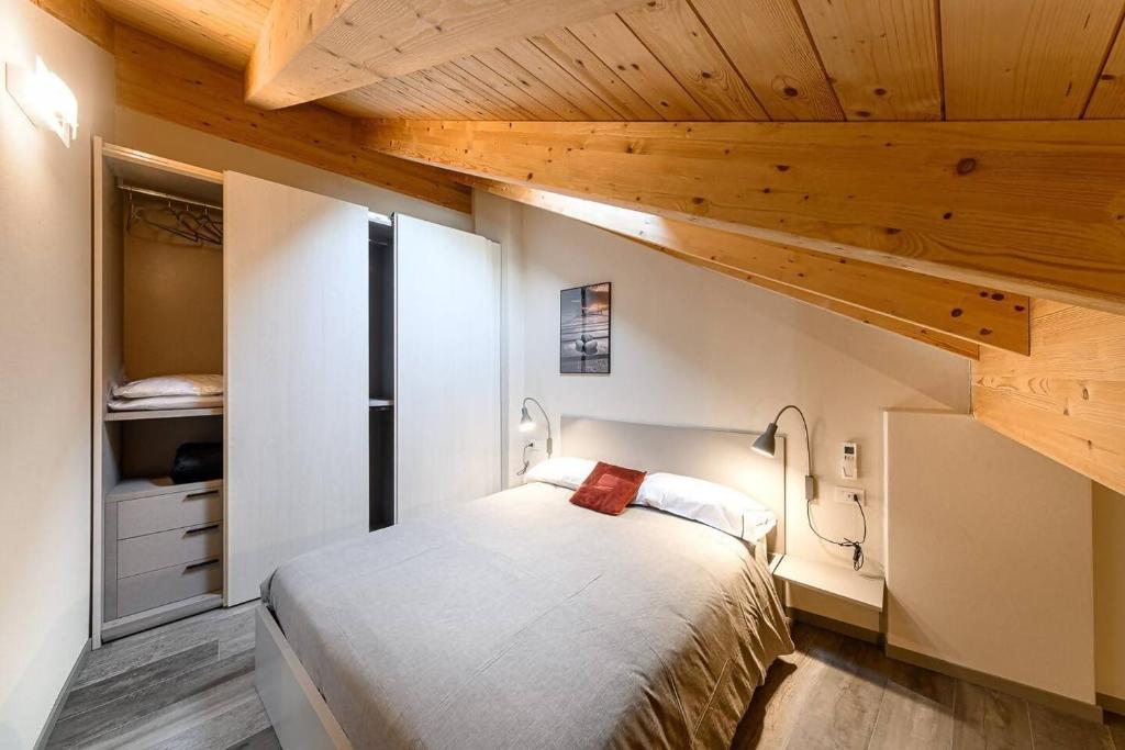 a small bedroom with a bed and wooden ceilings at Residenza Cavour - Appartamento D in Tirano