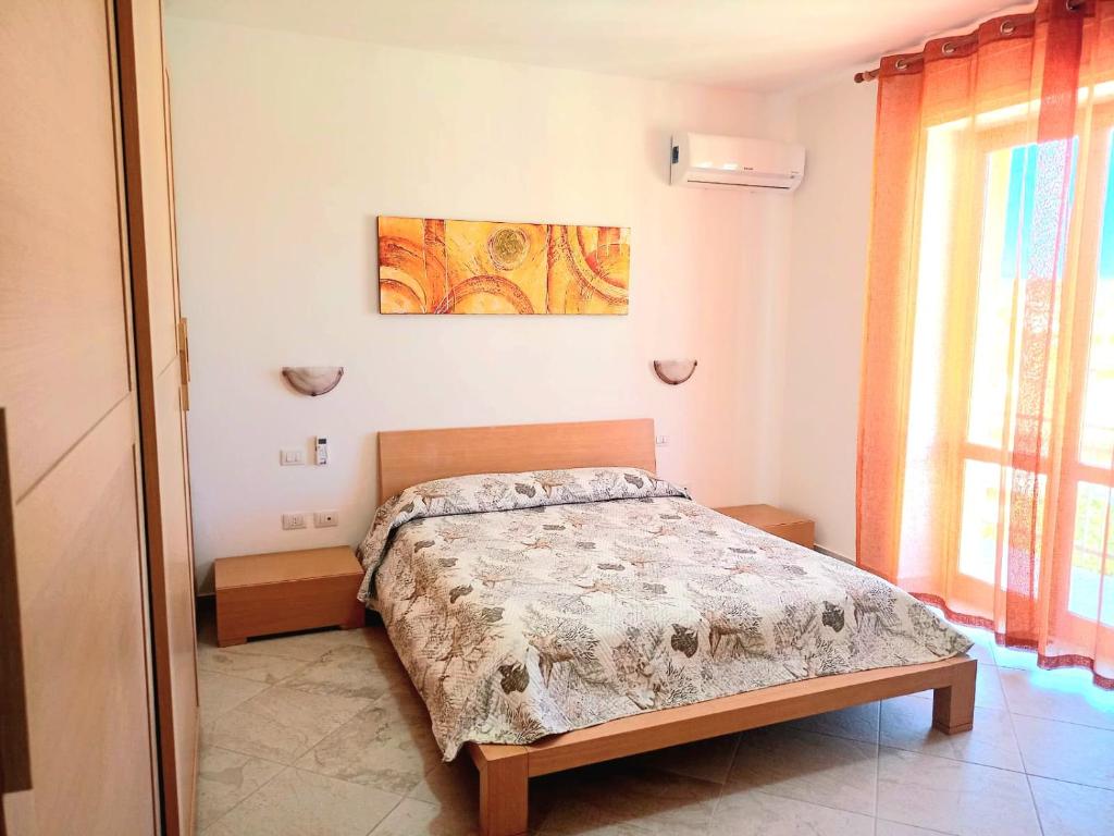 Un dormitorio con una cama y un cuadro en la pared. en Isola dei sogni, en Alghero