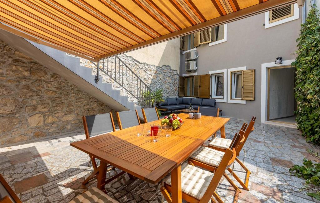 a wooden table and chairs on a patio at 4 Bedroom Stunning Home In Crikvenica in Crikvenica