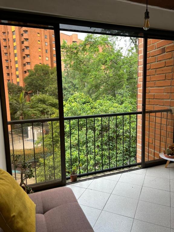 a room with a balcony with a view of trees at Casa Pantera in Medellín