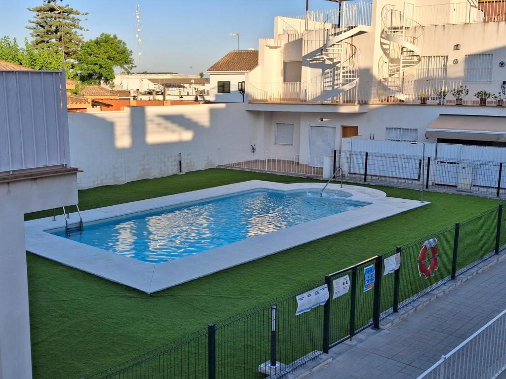 a large swimming pool on the side of a building at Apartamento Turístico Damajuana Parking Free in Espartinas