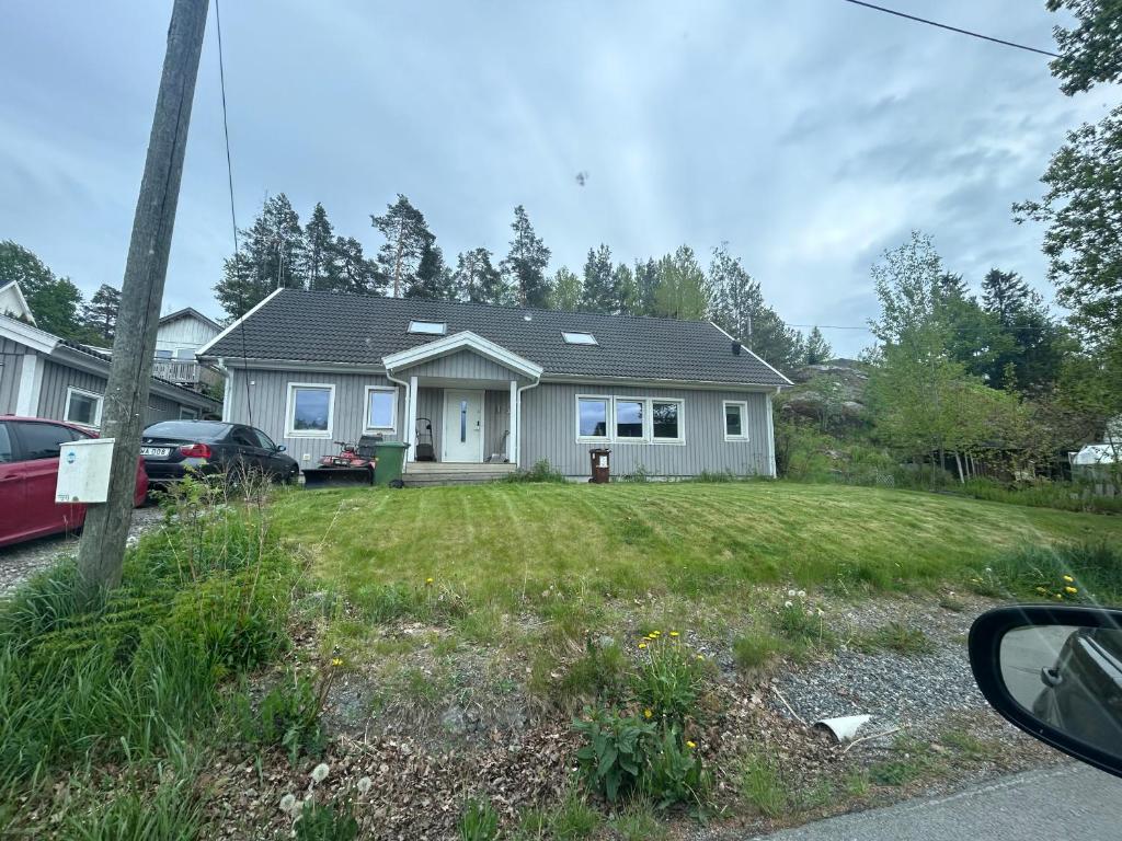 una casa blanca con un patio con césped en Cozy Room in Tyresö, en Tyresö