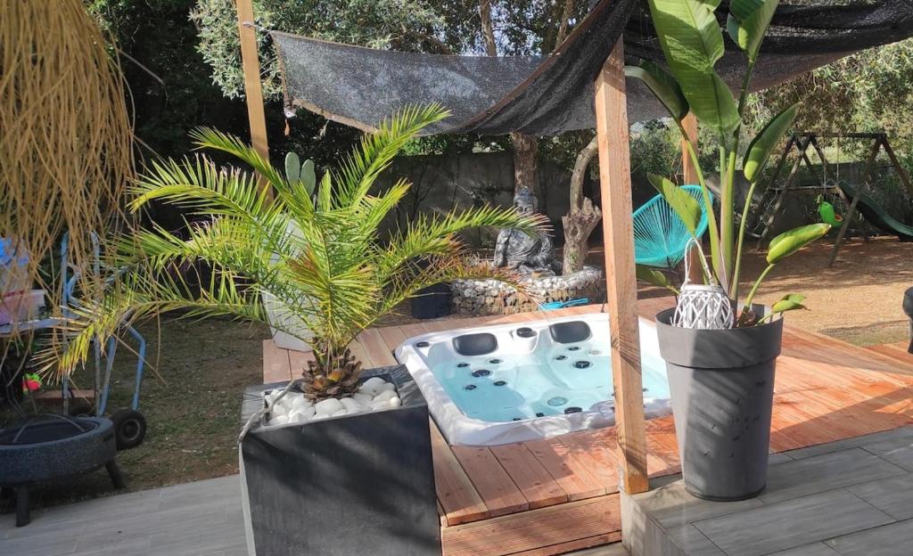 a backyard with a hot tub and some plants at Agréable maison avec jacuzzi in Vinassan