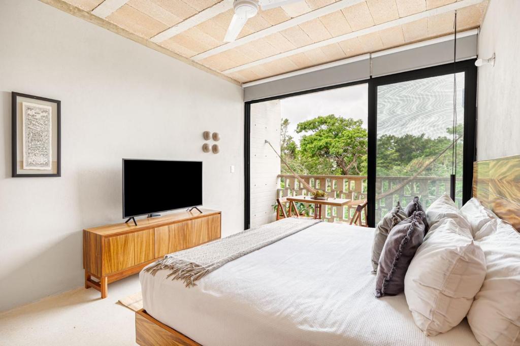 a bedroom with a large bed and a flat screen tv at Fabulous Loft With Pool in Cancún