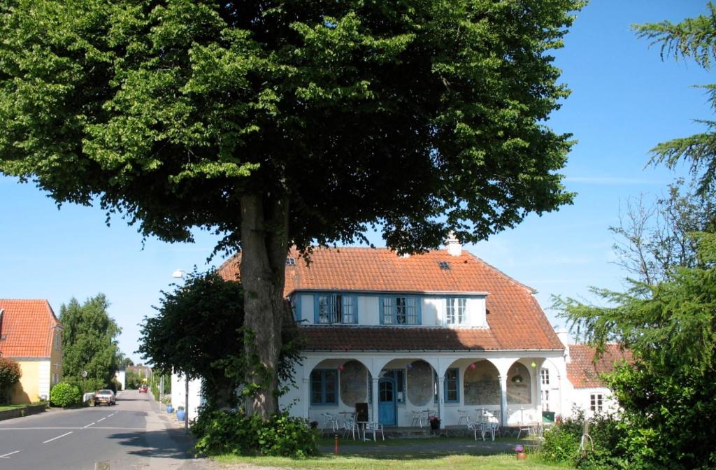 una casa con un árbol delante de ella en Thurø Kro B&B, en Svendborg