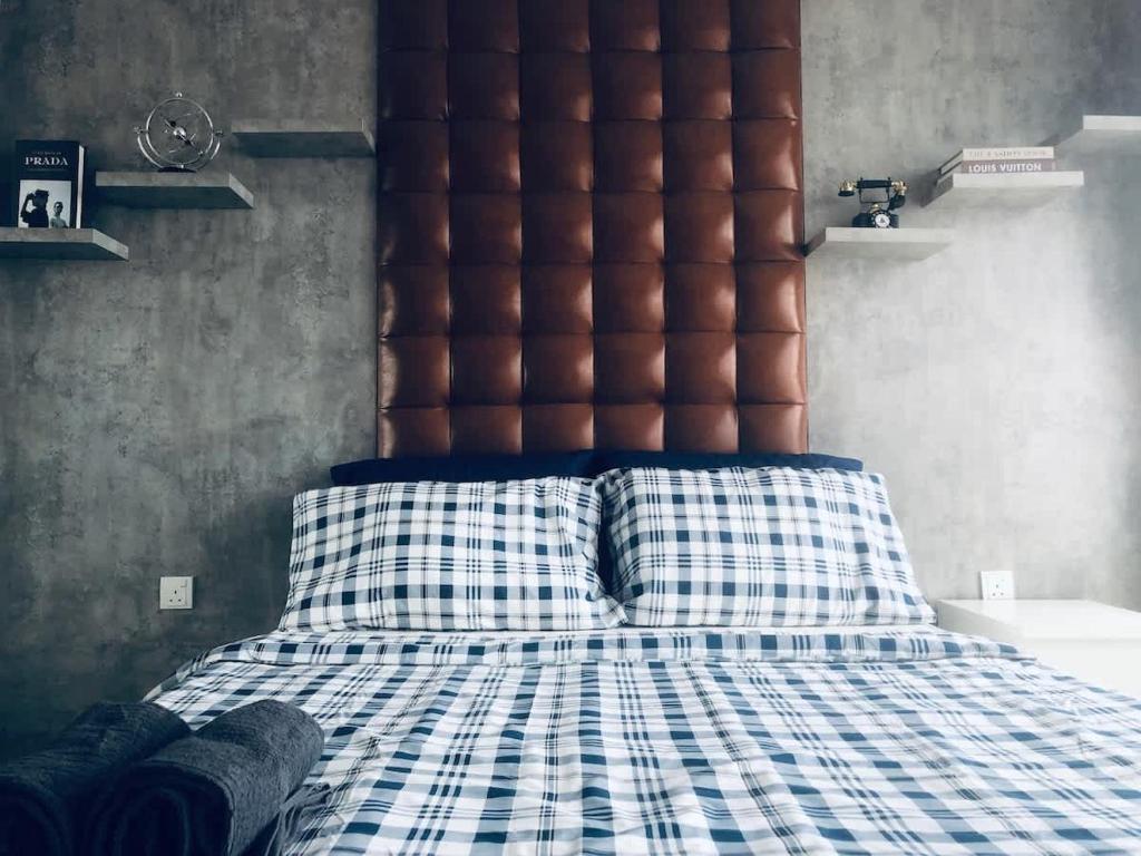 a bedroom with a large bed with a brown headboard at Vintage Homes at i-City - WiFi TV Box 1 Carpark in Shah Alam