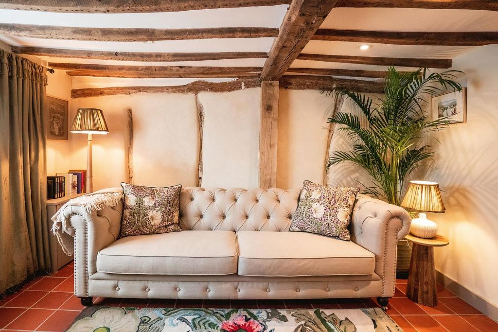 ein Sofa im Wohnzimmer mit einer Decke in der Unterkunft Straw Plaiters Cottage in Wendover