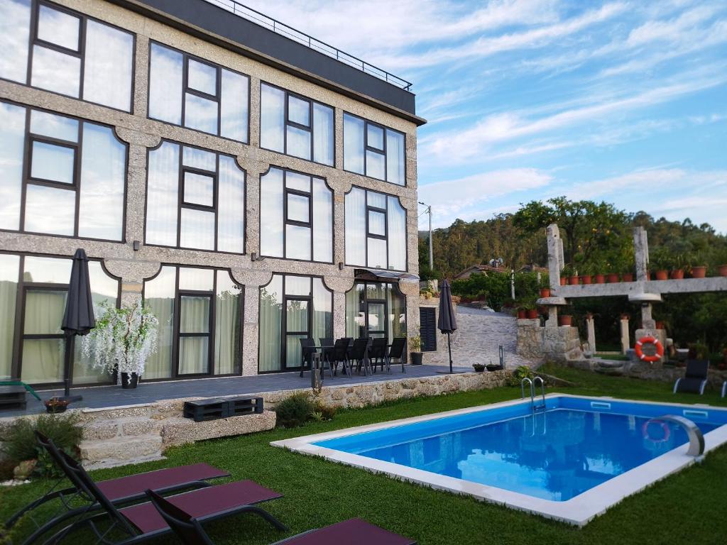 ein Haus mit einem Swimmingpool neben einem Gebäude in der Unterkunft Sequeira Arantes Casa 1 in Terras de Bouro