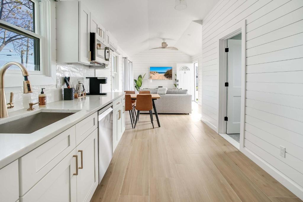 a kitchen with white cabinets and a sink and a table at Dockside 2BR - Marina - Dining - Charter Access Unit A in Montauk