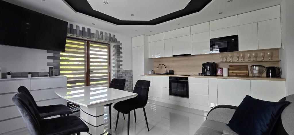 Una cocina con una mesa y sillas en una habitación. en Apartament u Krupy, en Murzasichle