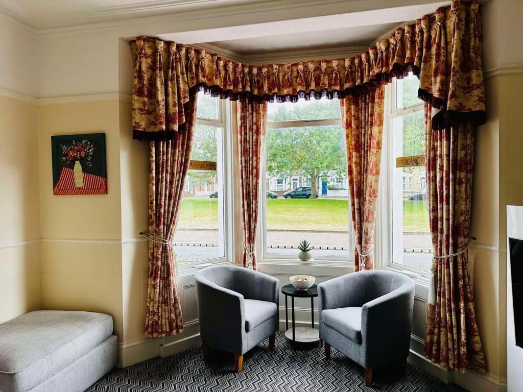 Una sala de estar con dos sillas y una ventana. en Rembrandt Guest House, en Great Yarmouth