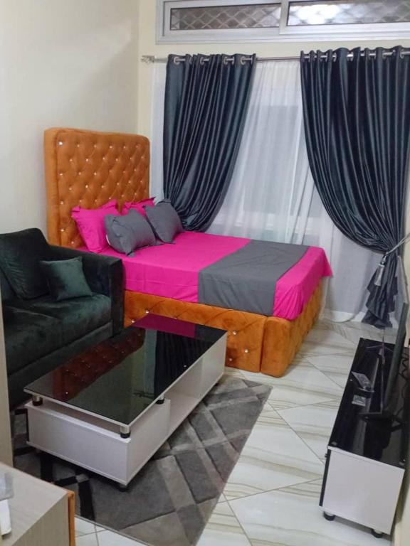 een slaapkamer met een bed, een bank en een raam bij Le Tounkaranké résidence ACI 2000 GREEN STUDIO autonome confortable climatisé full time installations solaires Eau chaude in Bamako