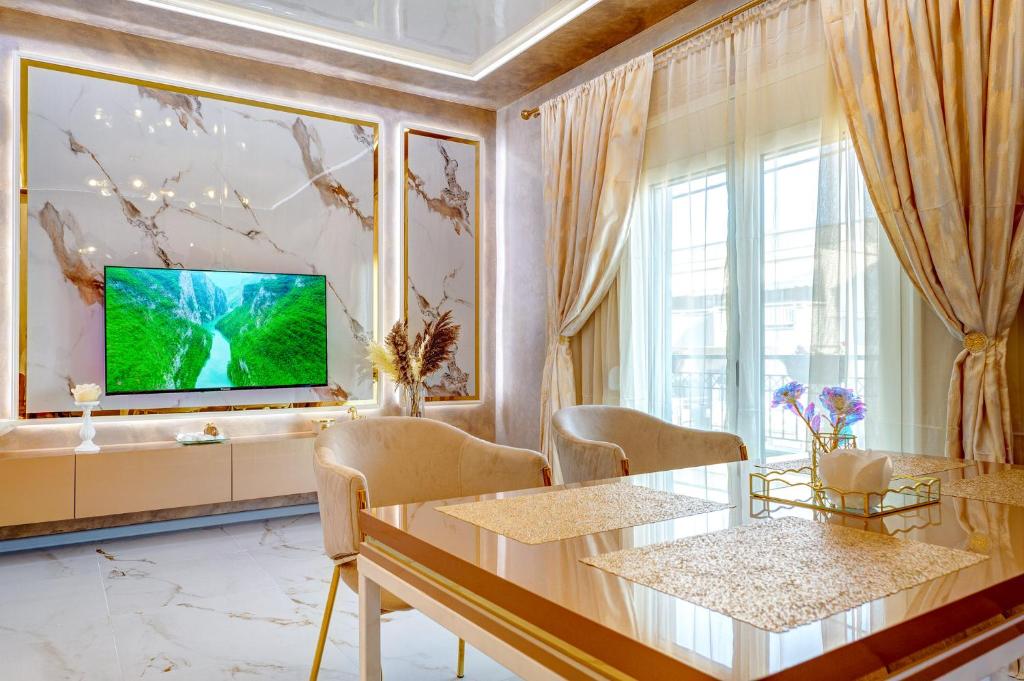 a living room with a large window and a television at Тематични апартаменти Дубай и Малдиви in Néa Péramos