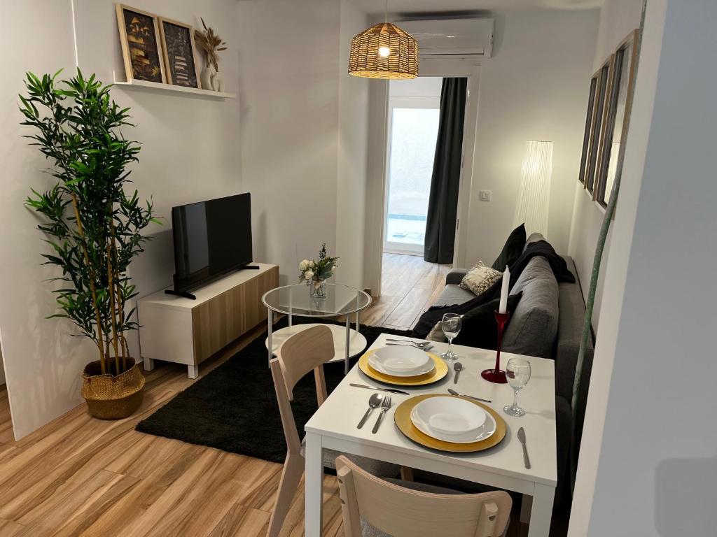 a living room with a white table and a tv at Apartamentos a Estrenar cerca de aeropuerto y centricos in Paracuellos de Jarama