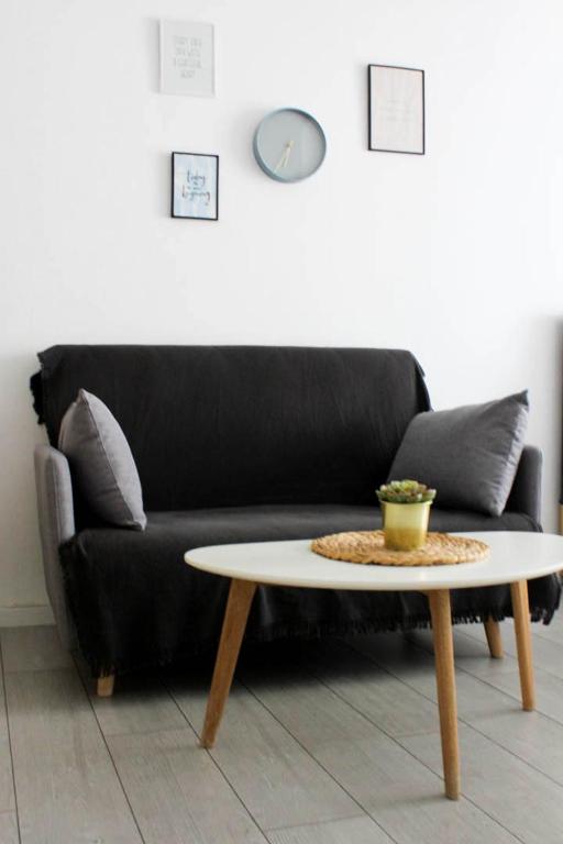 ein schwarzes Sofa mit einem Couchtisch im Wohnzimmer in der Unterkunft StuDio 57 (5) in Alexandroupoli