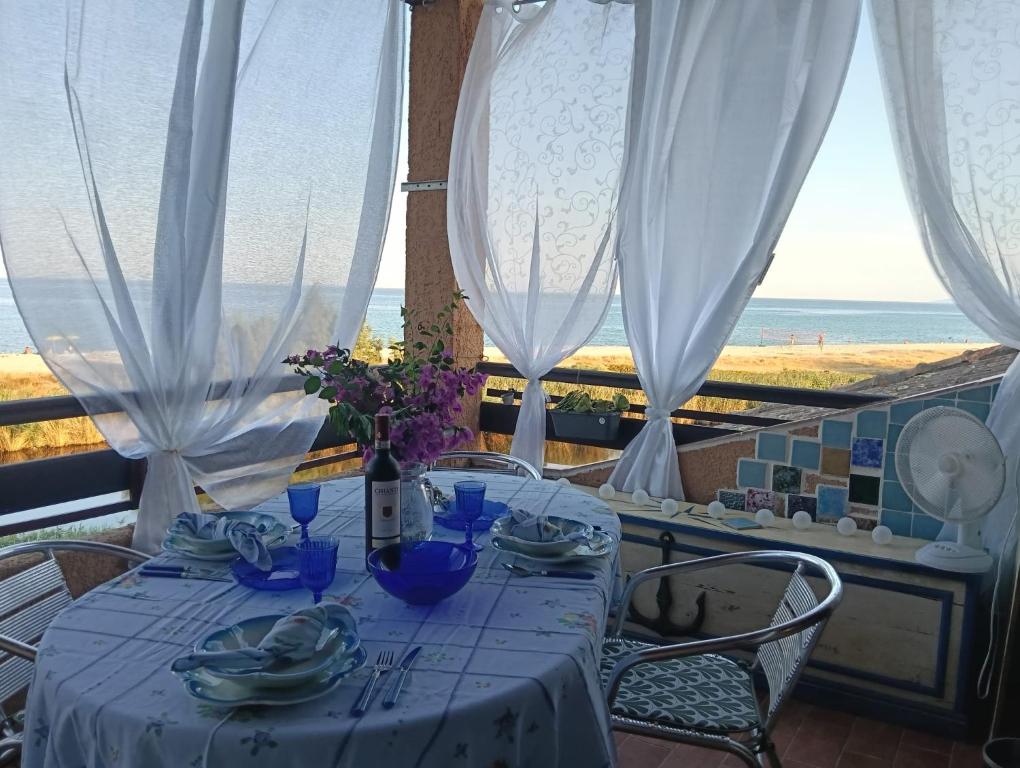 Una mesa con platos azules y vista al océano. en Le Rêve de Mer, en Ghisonaccia