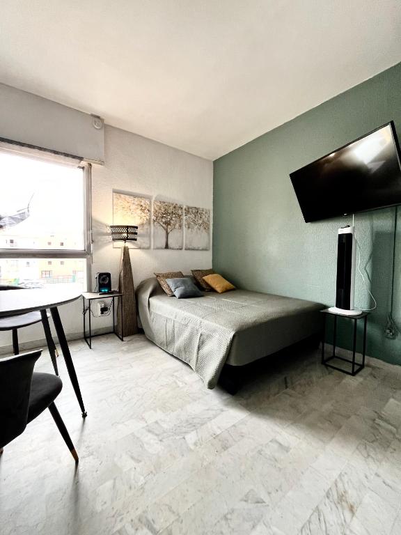 une chambre avec un lit, une table et une fenêtre dans l'établissement Studio Oiseau Bleu Plage Môle Port & Centre Cap d Agde, au Cap d'Agde