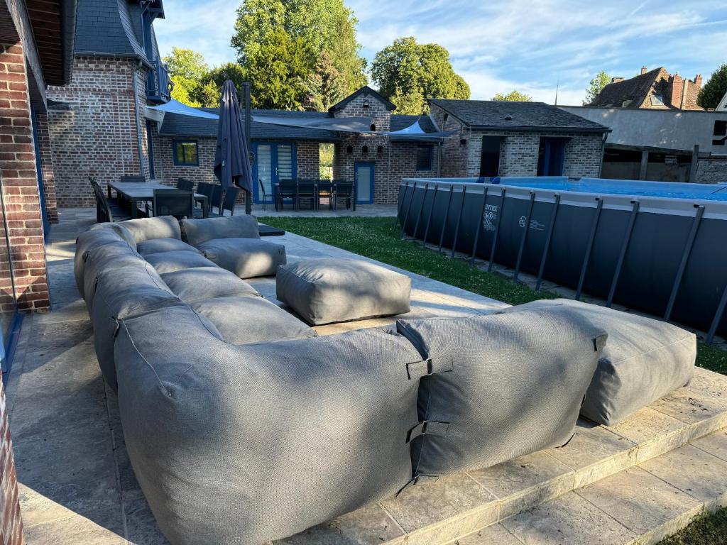 Un gran sofá sentado en el suelo en un patio. en Maison des Fontainettes, en Les Andelys