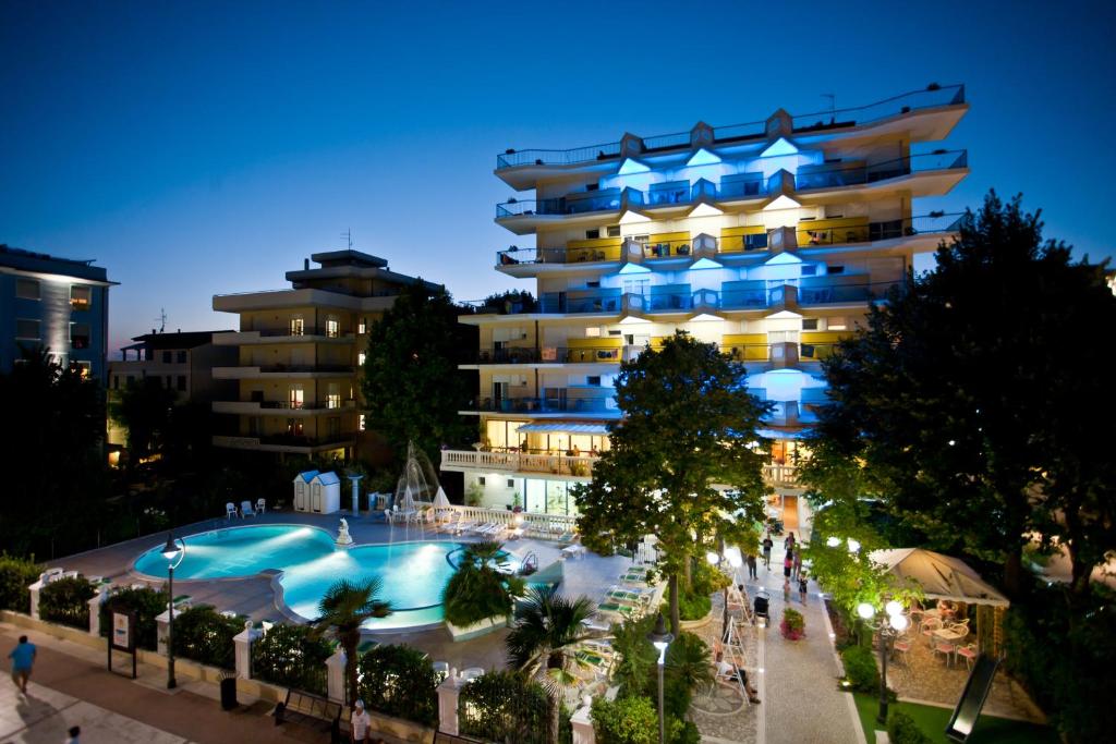 un hôtel avec une piscine en face d'un bâtiment dans l'établissement Hotel Miranda, à Bellaria-Igea Marina
