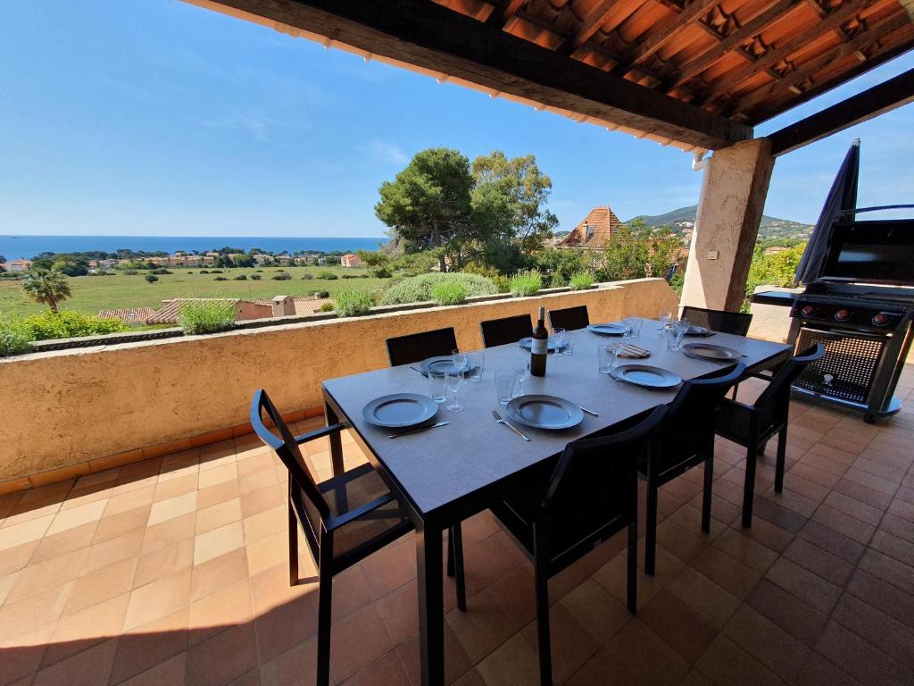 une table et des chaises sur une terrasse avec vue dans l'établissement Villa Horizon-Vue mer-Plages-WIFI-CLIM, à Carqueiranne