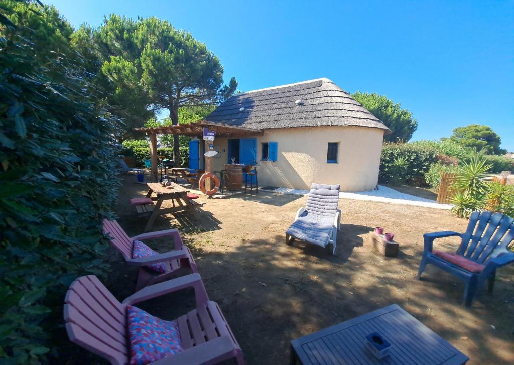 a group of chairs and a table and a house at 5 min du village de Noël Barcarès mas de pêcheurs 8 couchages tout confort in Le Barcarès