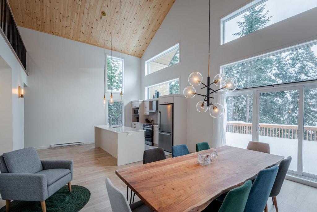 een eetkamer met een houten tafel en stoelen bij Chalet Odin - SPA, PISCINE, SAUNA partagés in Valcartier Station