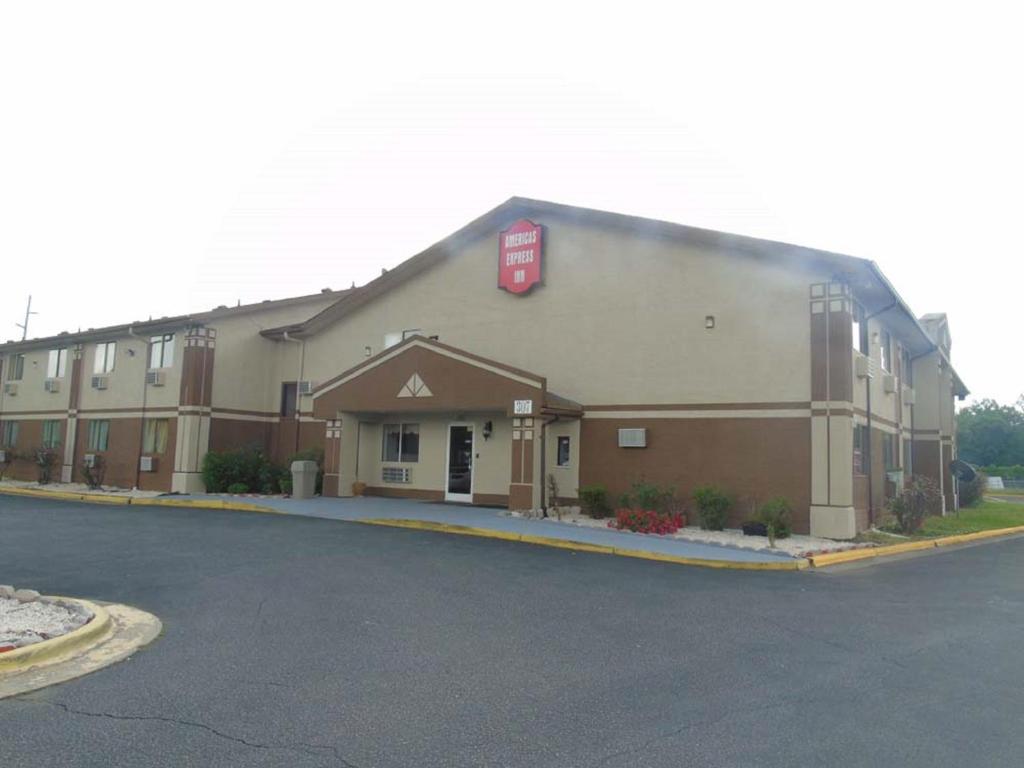 a large building with a sign on the side of it at Americas Express Inn Rocky Mount in Rocky Mount