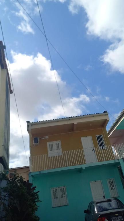 una casa amarilla y azul con un coche aparcado delante en my sweet place 10, en São Luís