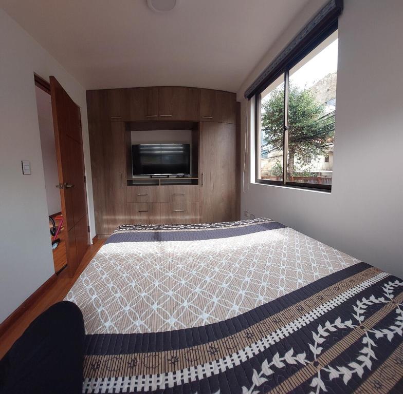 a bedroom with a bed and a tv and a window at Acogedor y soleado APT en La Paz in La Paz