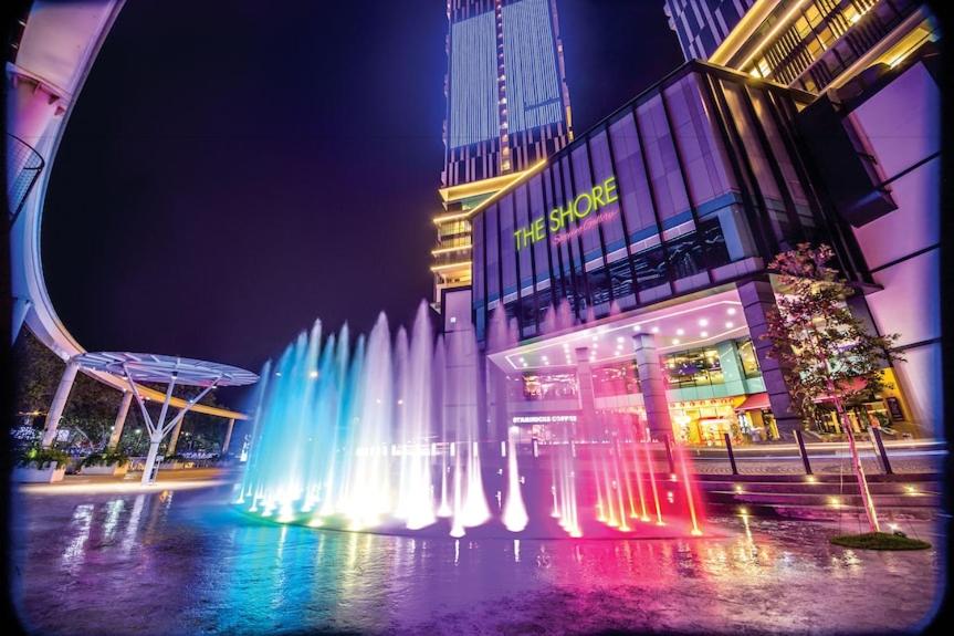 una fuente de agua frente a un edificio por la noche en The Shore Residence Melaka, en Melaka