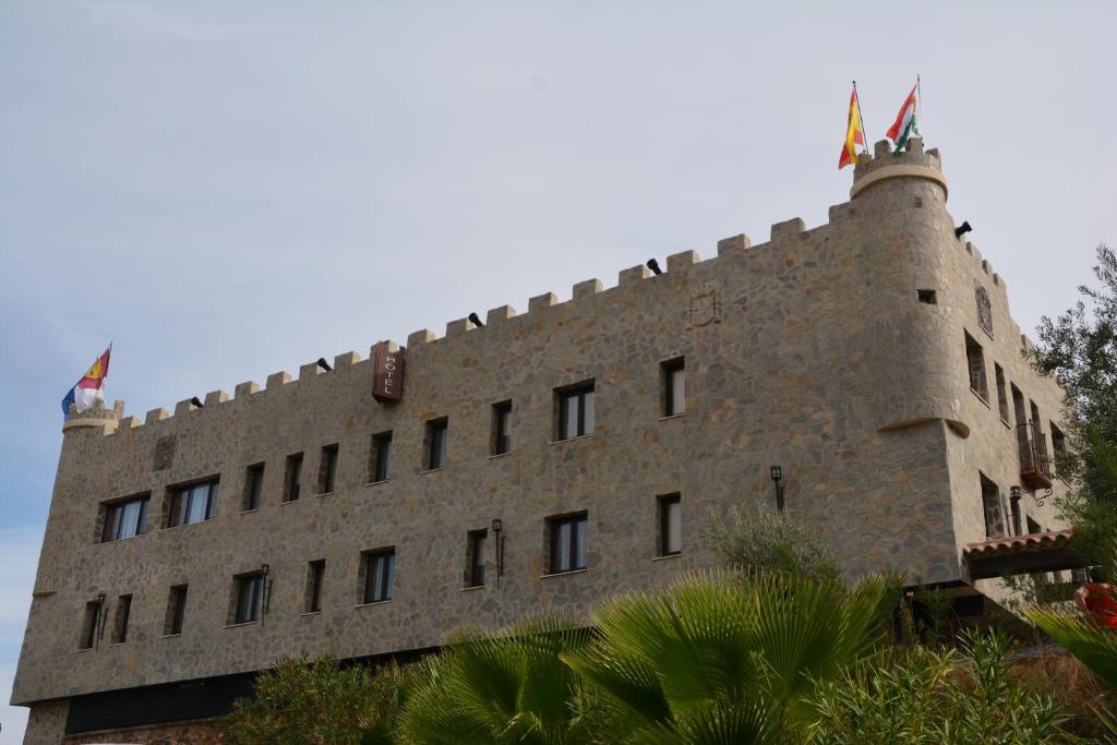 un grand bâtiment en briques avec des fenêtres sur son côté dans l'établissement Hotel Rural Restaurante Los Rosales, à Almadén
