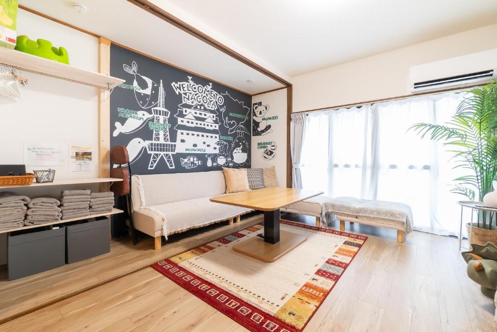 salon z kanapą i stołem w obiekcie 名古屋城に1番近い名古屋市北区若鶴民泊 w mieście Toyoyama