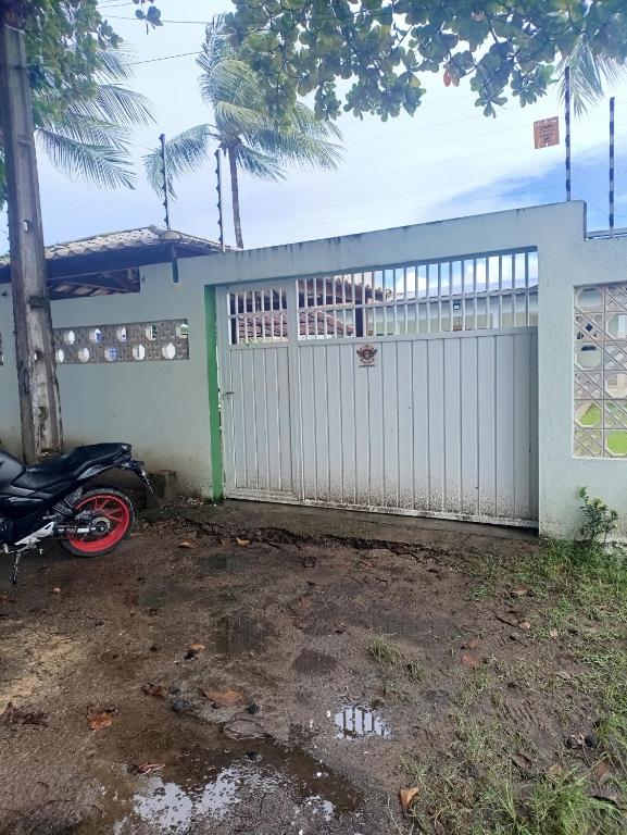 a motorcycle parked in front of a white fence at Flat em Porto de Galinhas-PE in Porto De Galinhas