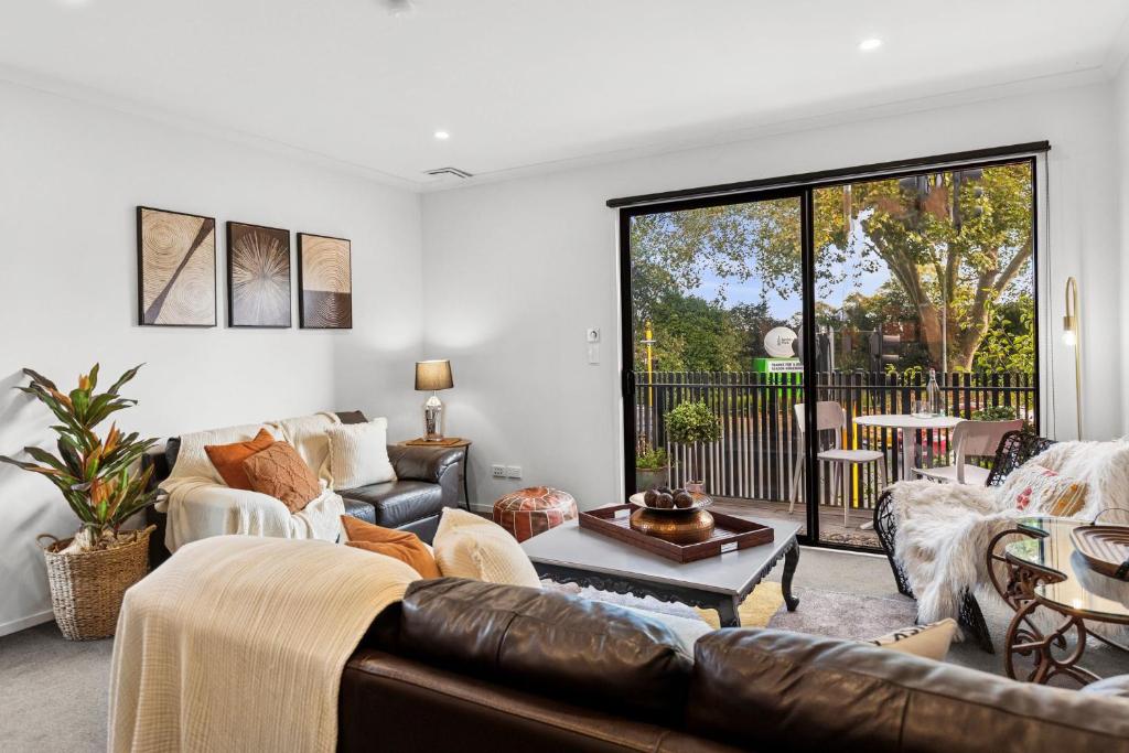 a living room with a couch and a table at Flash Stay Deal! Masterpiece Modern 3beds in Hamilton