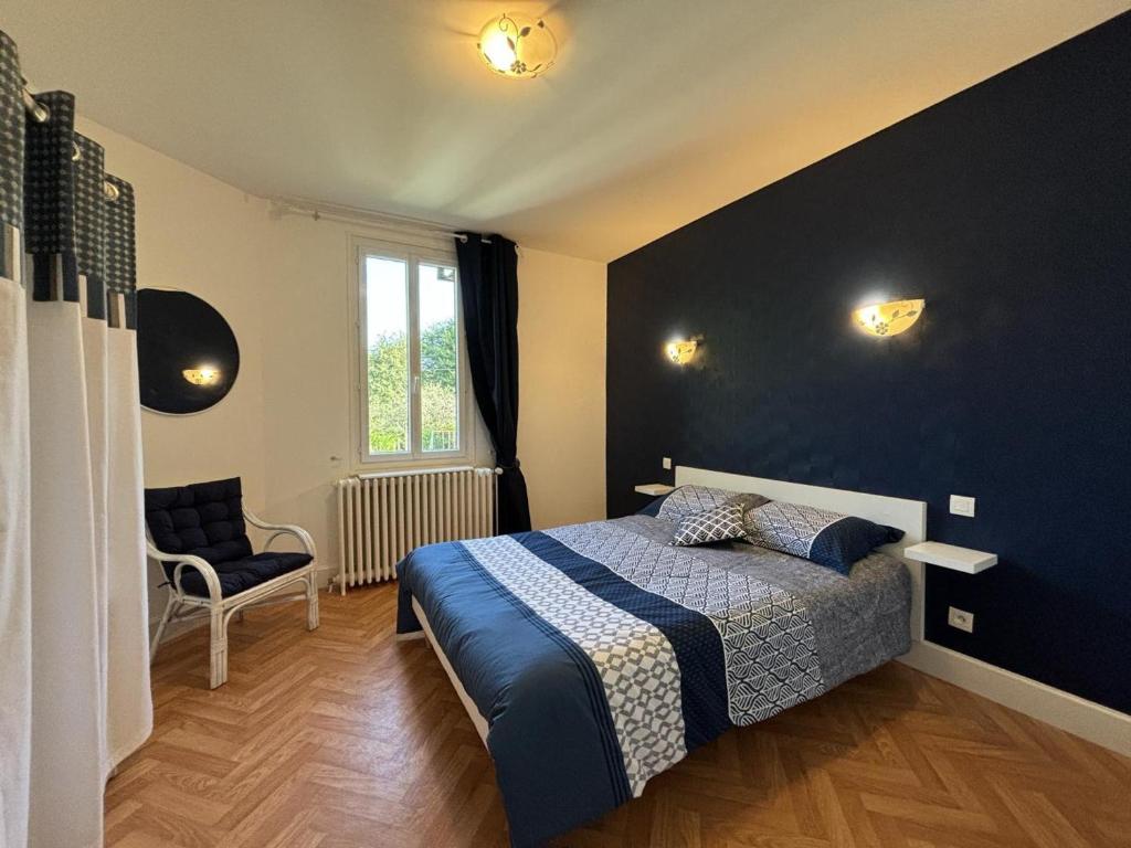 une chambre avec un lit et un mur bleu dans l'établissement Maison avec jardin près du canal et de la Loire, équipement complet, parfait pour familles - FR-1-489-550, à Diou