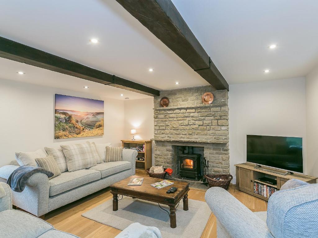 a living room with a couch and a fireplace at Manor Cottage in Tideswell