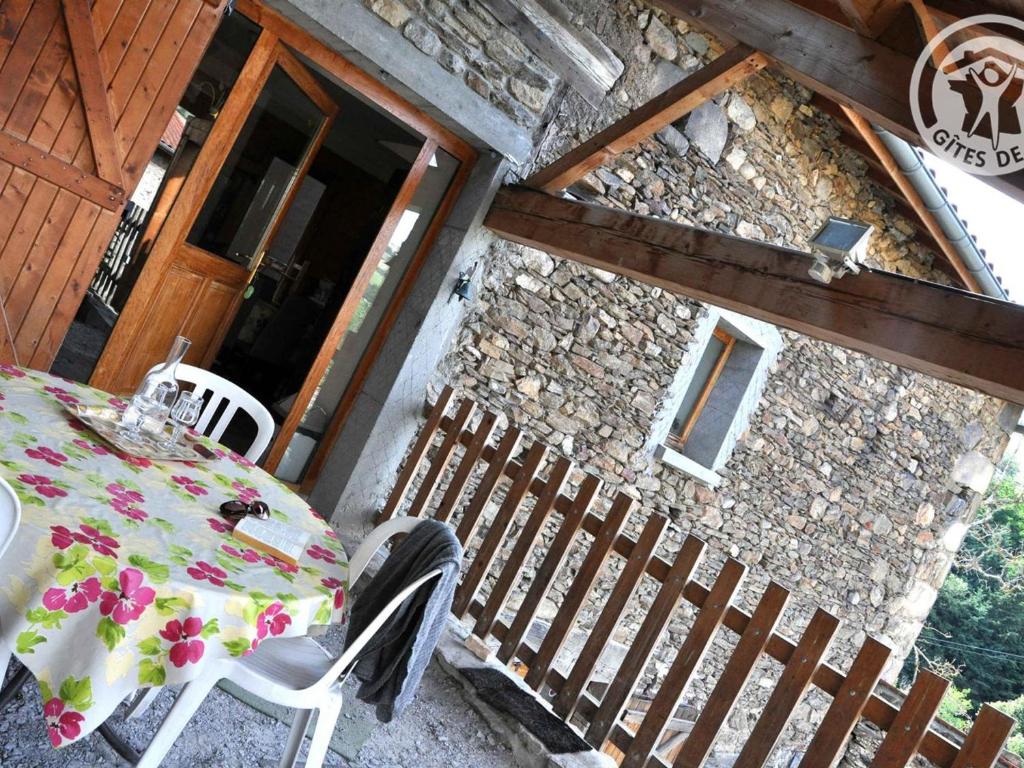 - une table et des chaises sur la terrasse couverte d'une maison dans l'établissement Gîte spacieux près de St-Etienne, idéal pour famille nombreuse - FR-1-496-73, à La Terrasse-sur-Dorlay
