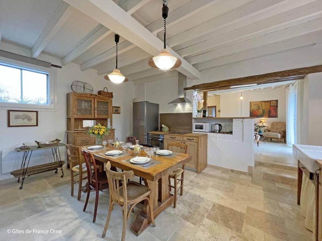 eine große Küche mit Holztisch und Stühlen in der Unterkunft Maison de campagne restaurée dans le Perche, animaux acceptés - FR-1-497-195 in La Roberie
