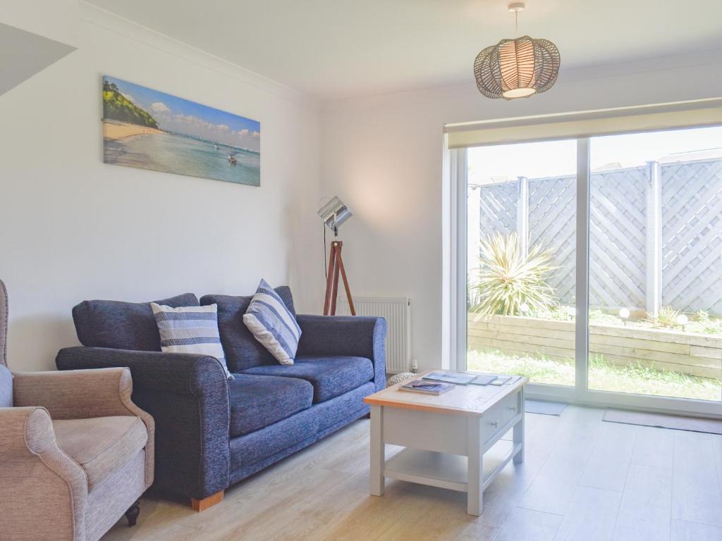 Una sala de estar con un sofá azul y una mesa. en Coastal Soul - Uk43464, en Sandown