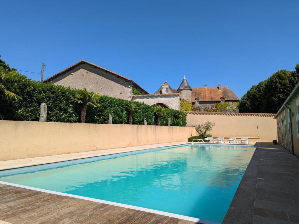 a swimming pool in front of a fence at Charmante Maison de Campagne avec Piscine Chauffée en Charente - FR-1-653-278 in Abzac