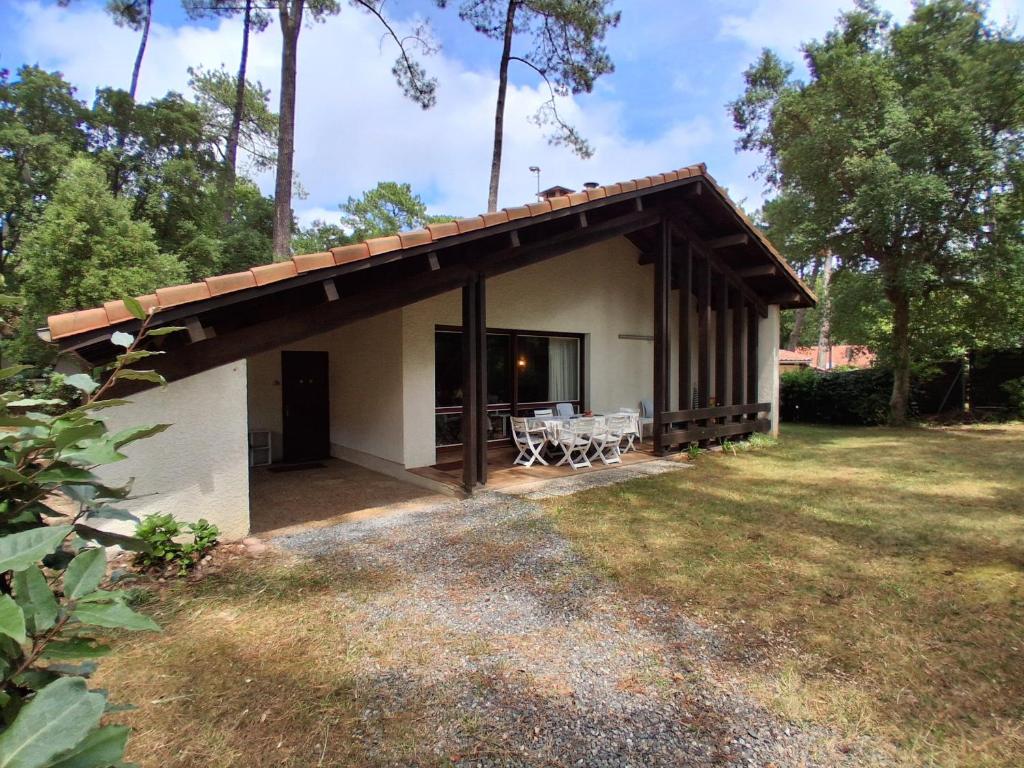 - un pavillon avec une table et des chaises dans la cour dans l'établissement Maison Plain-pied avec Jardin, Proche Plage et Pistes Cyclables, 6 Pers, Wifi, Parking - FR-1-239-436, à Seignosse