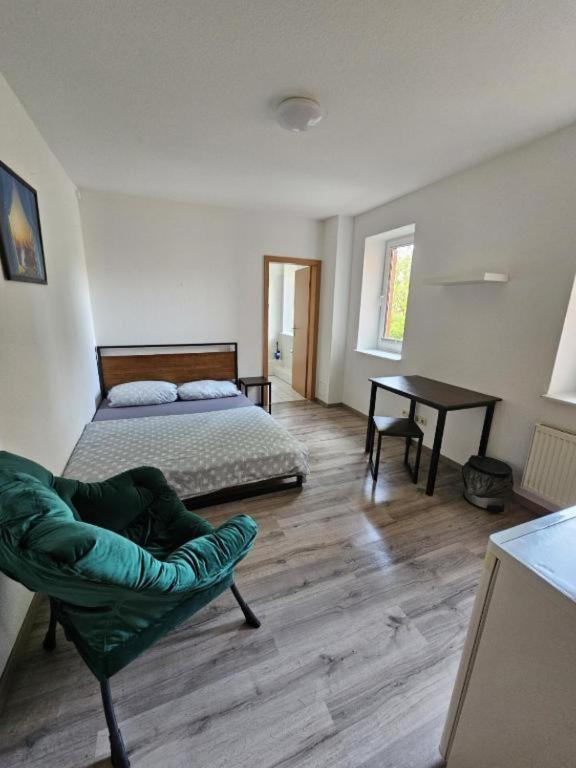 a bedroom with a bed and a chair and a table at Private room with private bathroom in Rostock
