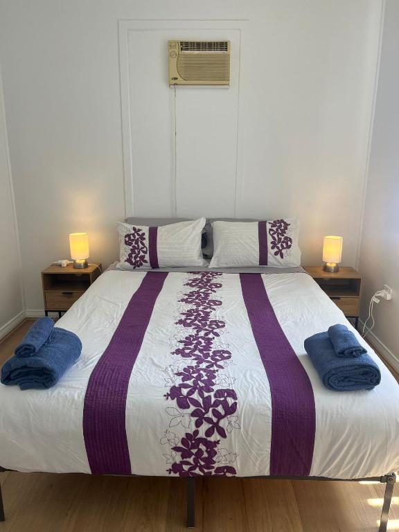 a bedroom with a large bed with two night stands at CozyHomes Woolloongabba B&B in Brisbane