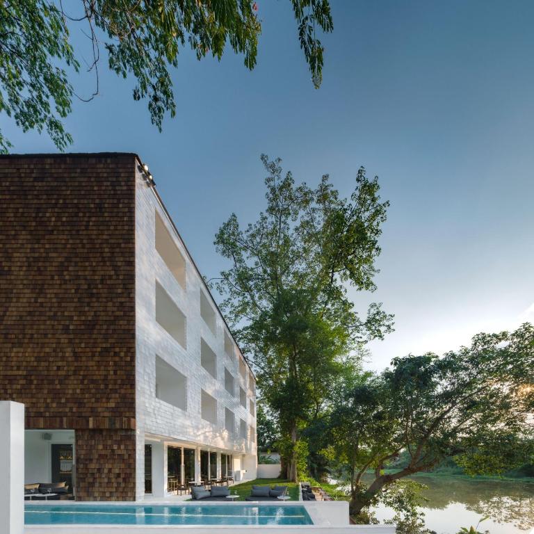 a building with a pool in front of it at Little Shelter Hotel Chiangmai in Chiang Mai